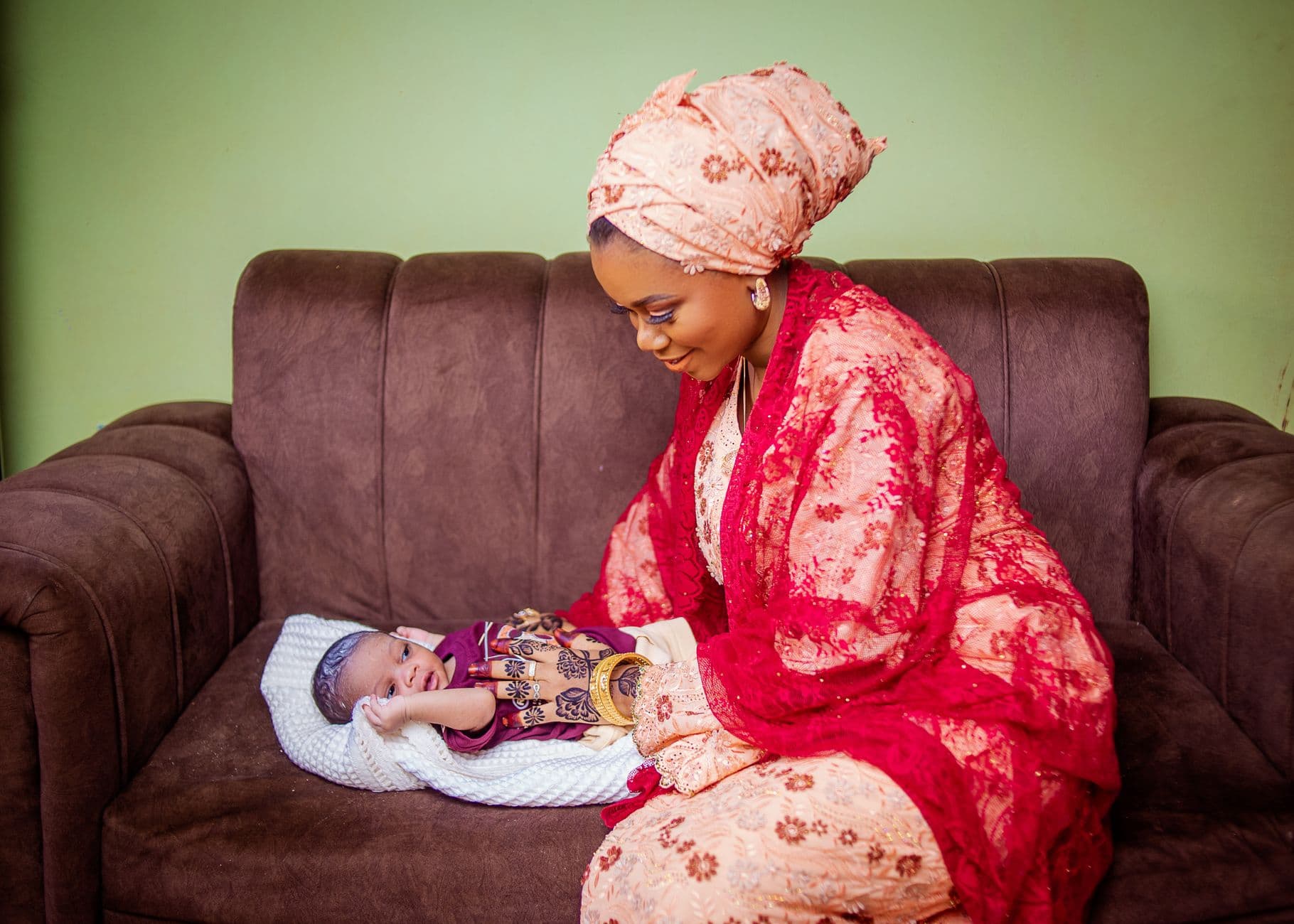 African mother in traditional attire with her newborn baby